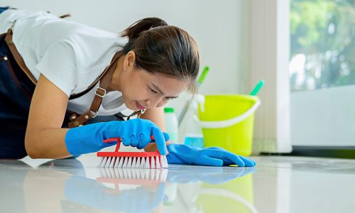 Cleaning Service concept. Cleaners employee removing dirt with equipment in office.